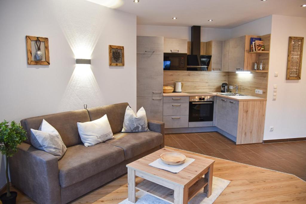 a living room with a couch and a table at Mountain View Appartements mit Blick NORDKETTENBLICK in Innsbruck