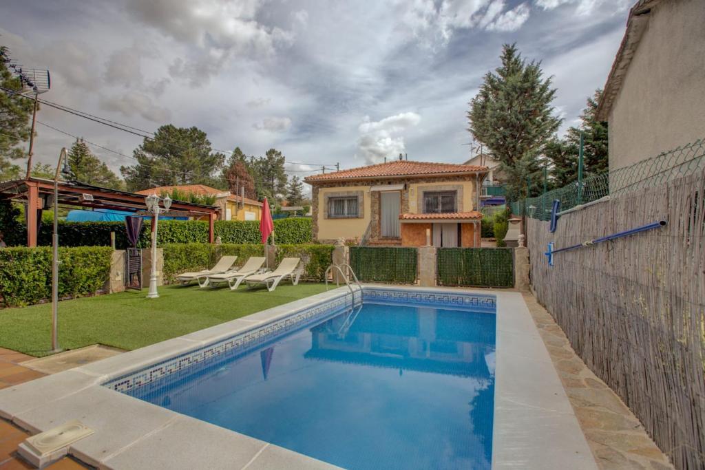 a swimming pool in a yard with a house at Casa rural Higueras in Santa María de la Alameda