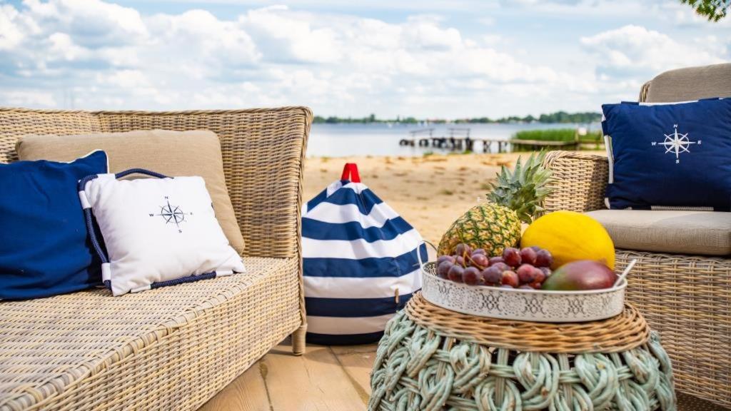 a table with a bowl of fruit on a beach at Relax place & restaurant in Zegrze Południowe