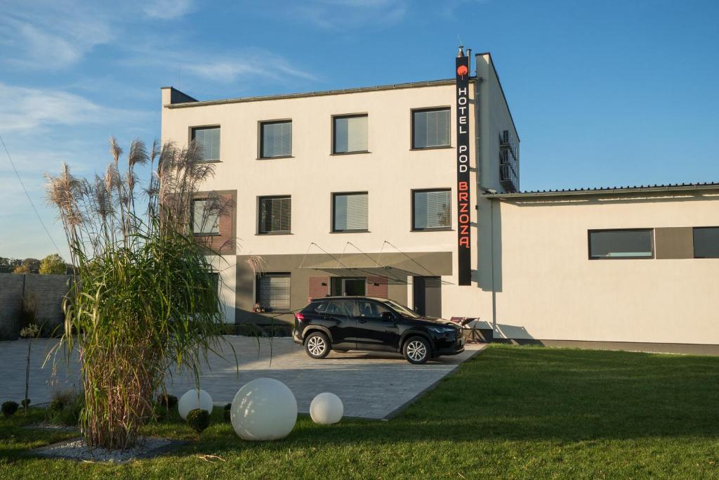 a black car parked in front of a building at Hotel Pod Brzozą in Strzelce Opolskie