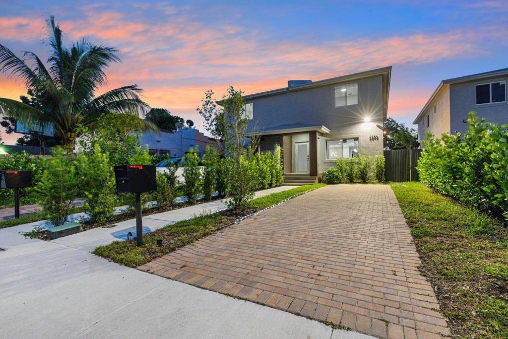 a house with a brick walkway in front of it at 4 Bedroom Holiday Retreat BBQ Marketplace in Miami