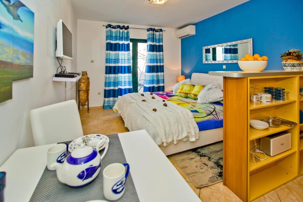 sypialnia z niebieskimi ścianami i łóżkiem ze stołem w obiekcie Villa Softic w Hvarze