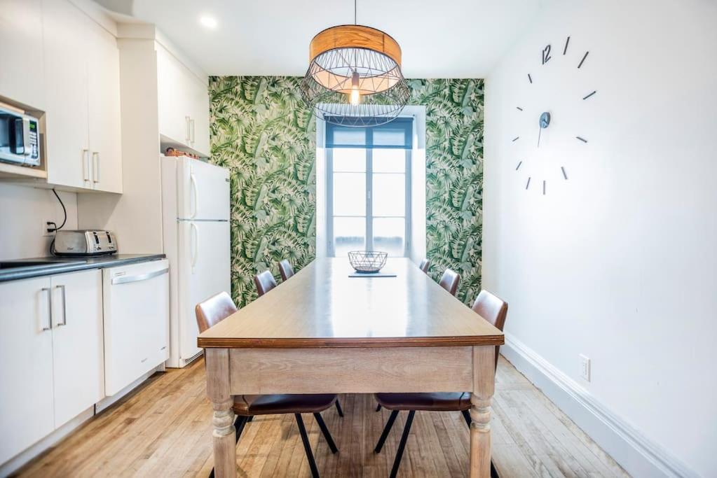 uma cozinha com uma mesa de madeira e cadeiras em La Maison Grenier La Résidence Beauport em Cidade de Quebec