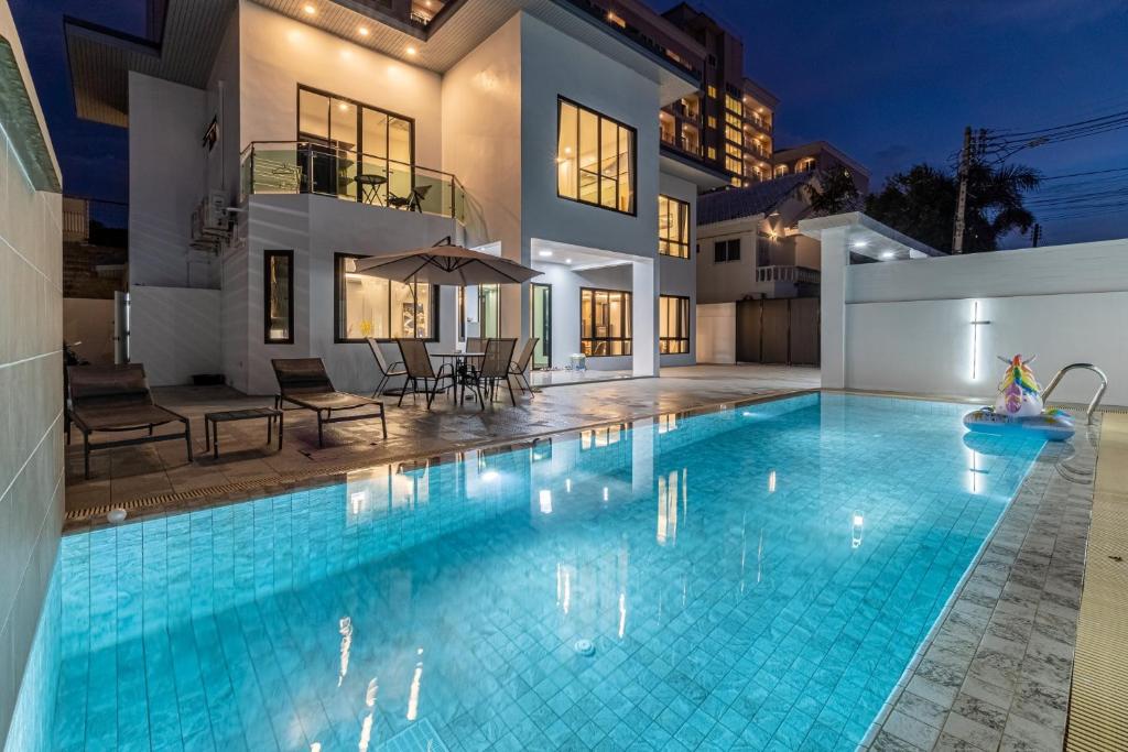 una piscina en el patio trasero de una casa en King 【芭提雅市中心独栋villa】【泳池】【5卧7卫】【独立KTV包厢】【豪华装修】, en Pattaya South