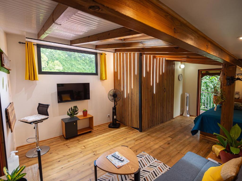 salon z dużym oknem i kanapą w obiekcie Kalinao - Bungalow chic en nature w mieście Les Abymes
