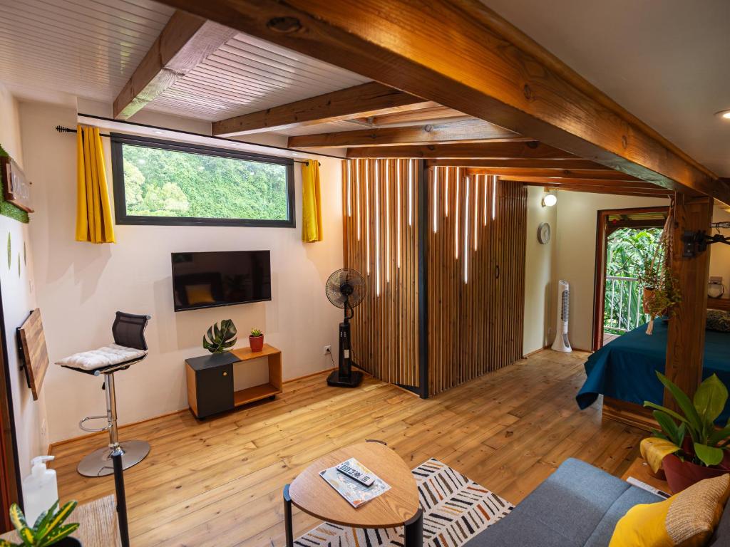 a living room with a large window and a couch at Kalinao - Bungalow chic en nature in Les Abymes