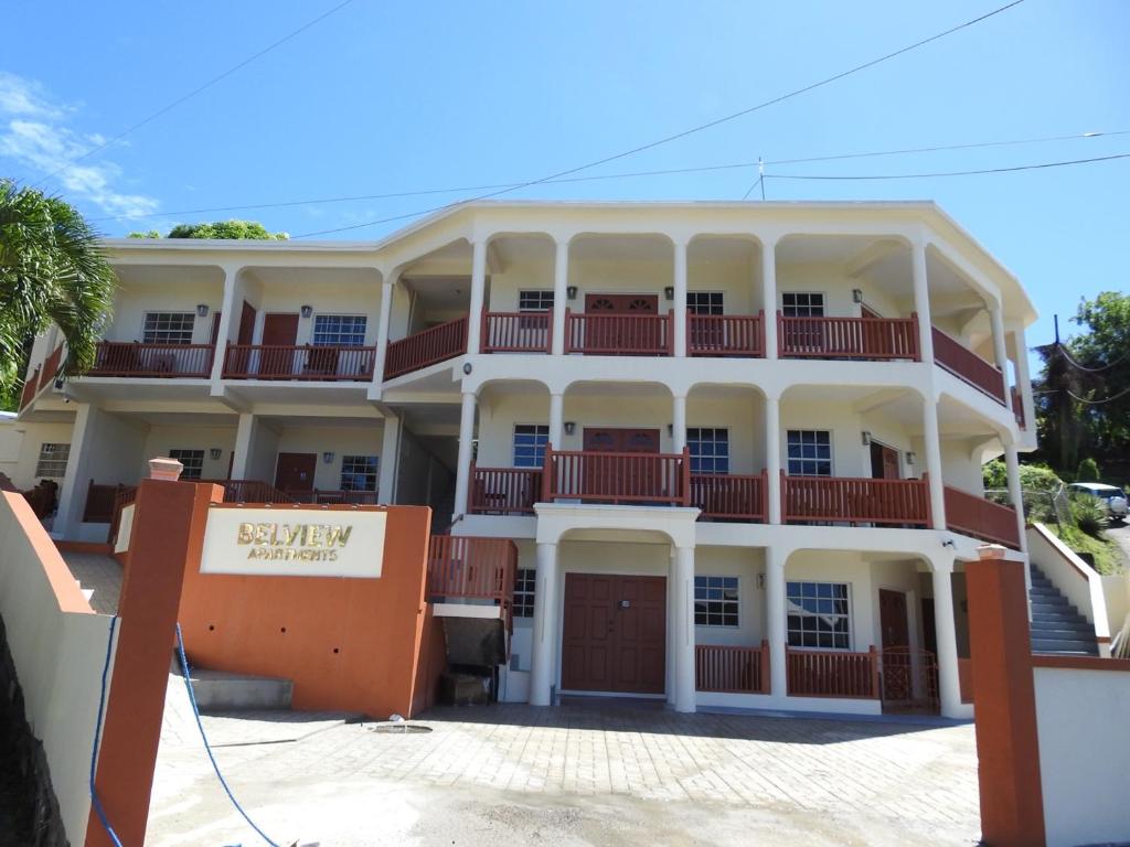 un gran edificio blanco con balcones rojos en Belview Apartments en Belmont