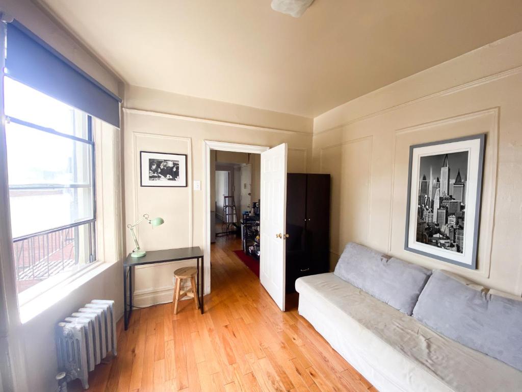 salon z kanapą i oknem w obiekcie 2 Bedrooms Entire Beautiful Apt in Williamsburg! w mieście Brooklyn