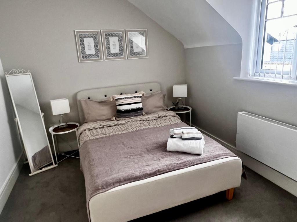 a bedroom with a bed with two tables and two lamps at Lakeside LUX bedroom with parking, M4 Jct 11, next to train station in Reading