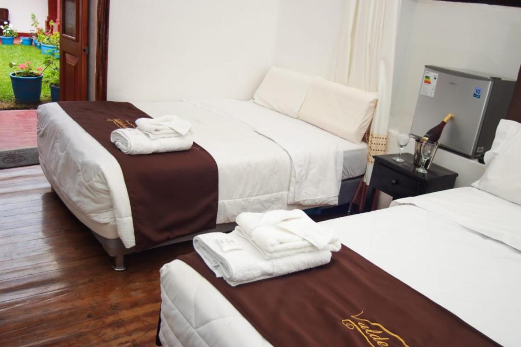 Casona Valdelirios Hotel في اياكوتشو: غرفه فندقيه سريرين عليها مناشف