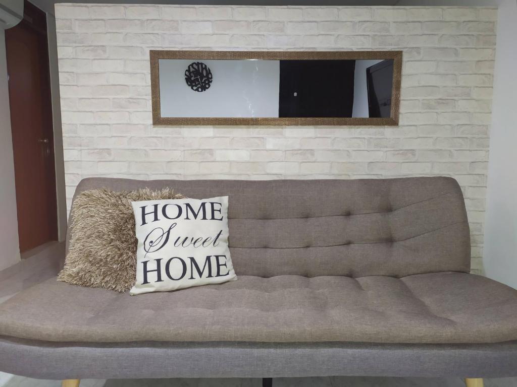 a couch with two pillows on it in a living room at Cómodo apartaestudio en Cali para corta o larga estadía in Cali