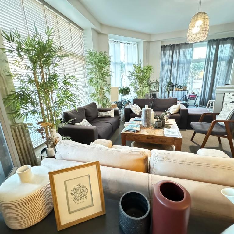 a large living room with couches and a table at Cit'Hotel Les Alizes in Dinard