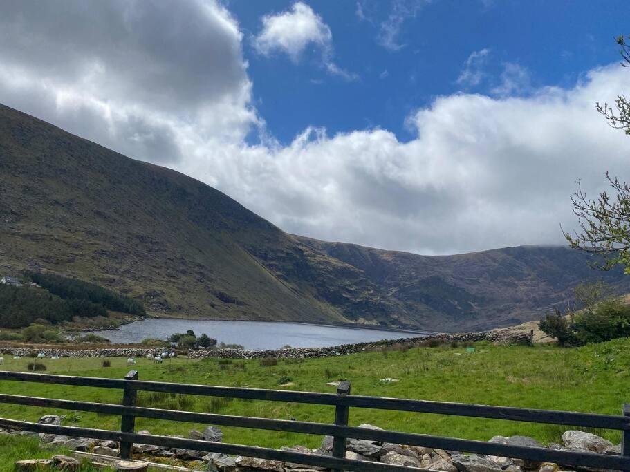 einen Zaun neben einem See in den Bergen in der Unterkunft Cois Locha in Glenbeigh