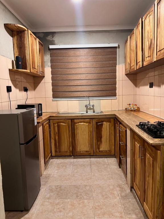 阿魯沙的住宿－City Retreat 8-8，厨房配有木制橱柜和不锈钢冰箱。