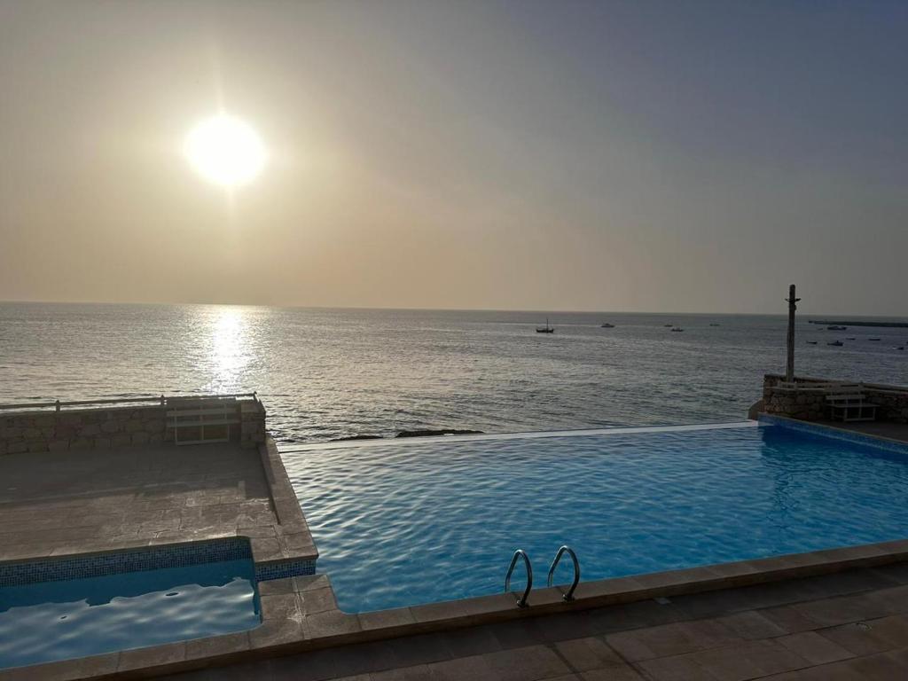a swimming pool with a view of the ocean at Stella Maris Da Costa Apartament in Calheta Do Maio