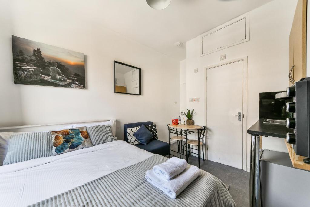 una camera con letto, sedia e televisore di Chapel Market Apartment a Londra