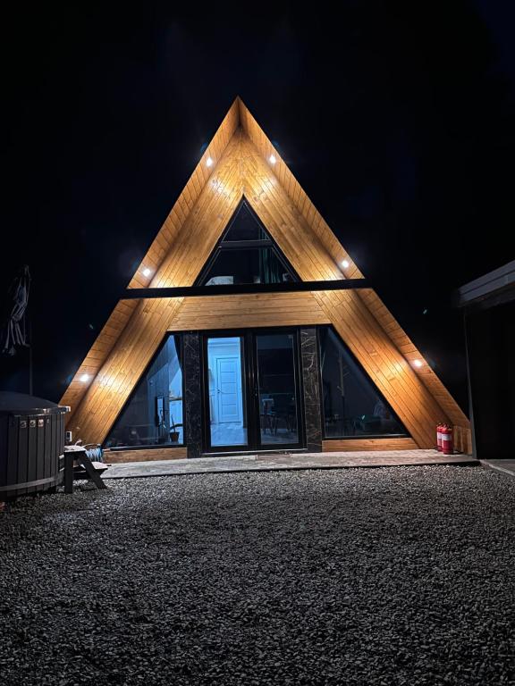 a house with a triangular roof at night at Cabana Green Hill in Borşa