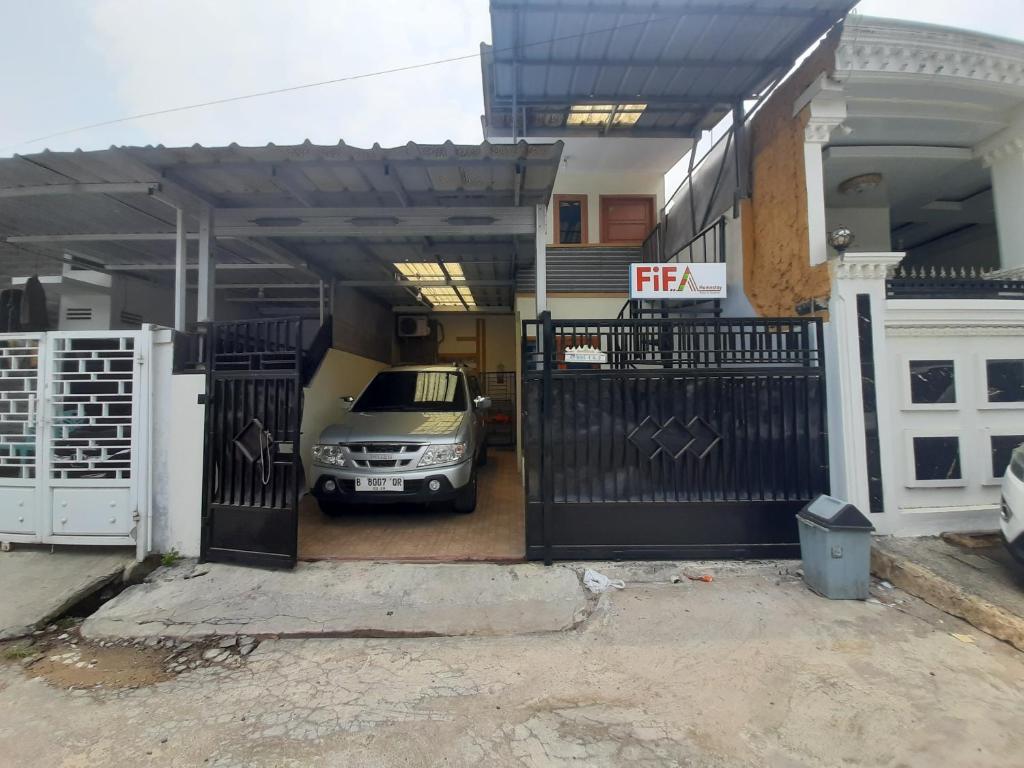 a car parked in a garage next to a house at Fifa Homestay & Villa 2BR in Tanjungkarang