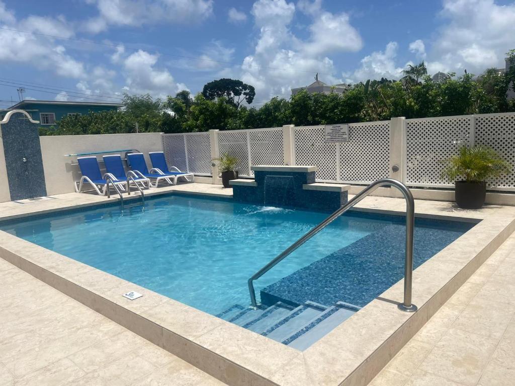 a swimming pool with chairs and a table in it at Melbourne Inn in Christ Church