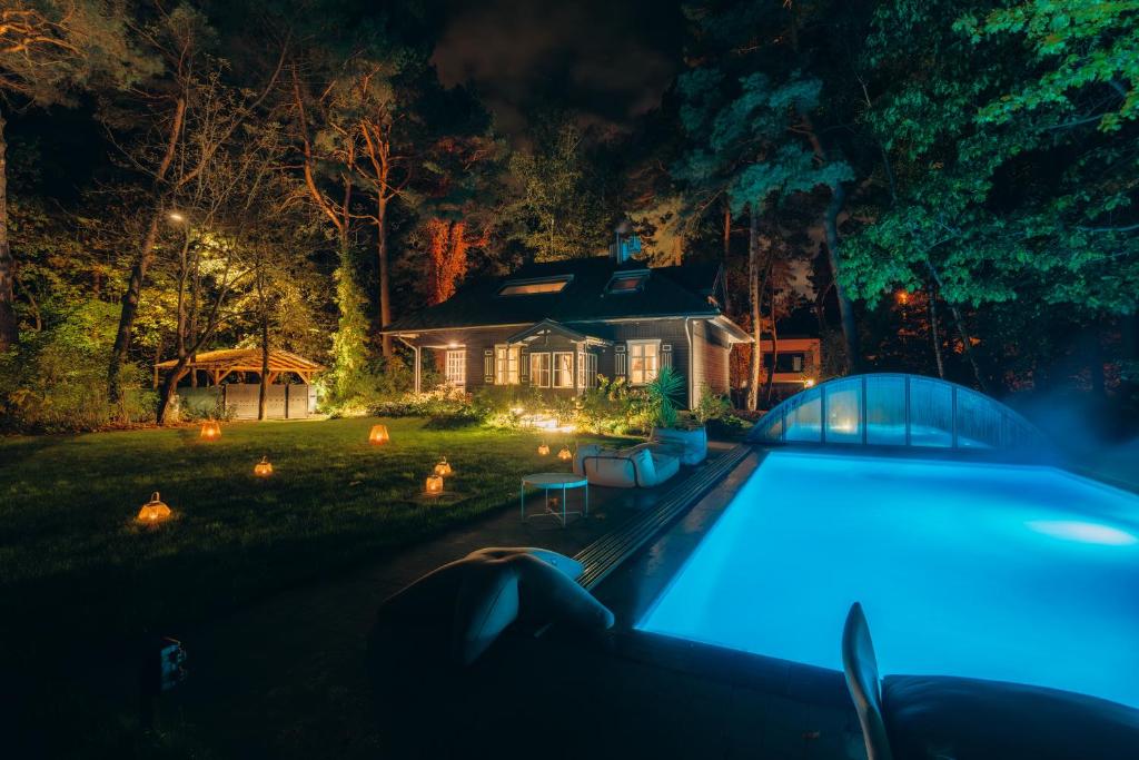 una casa con piscina por la noche en Joy Village en Varsovia