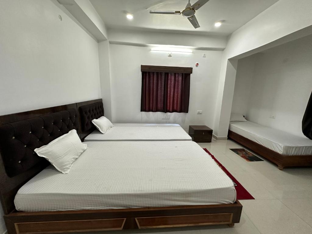 a bedroom with two beds and a window at UTSAV PALACE in Bodh Gaya