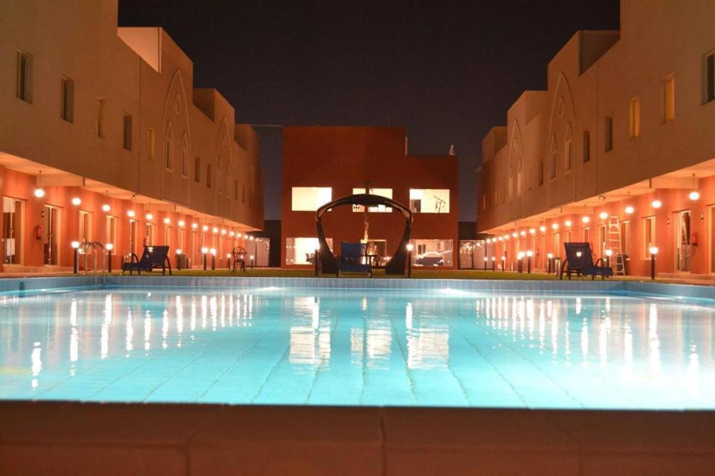 a large swimming pool in a building at night at فردان ريزيدانس - جدة Verdun Residence Jeddah in Obhor