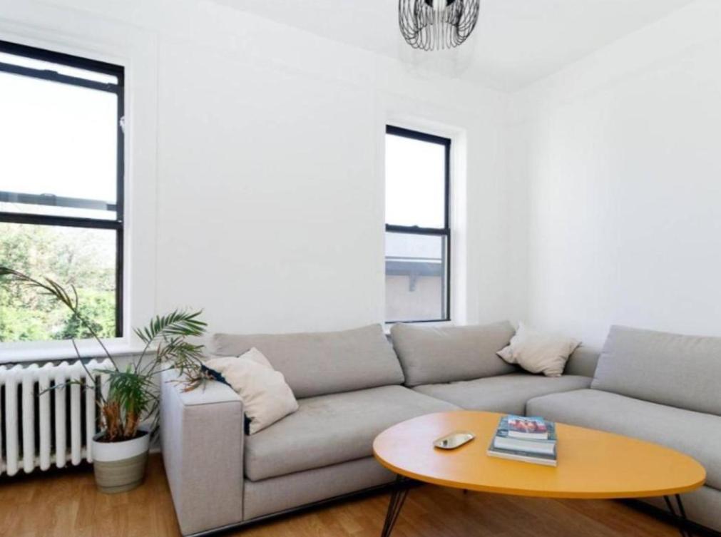 een woonkamer met een bank en een tafel bij Stunning 3BR Apartment in NYC! in New York