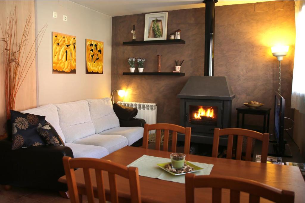 a living room with a couch and a table with a fireplace at Apartamento Gis con chimenea in Ribes de Freser