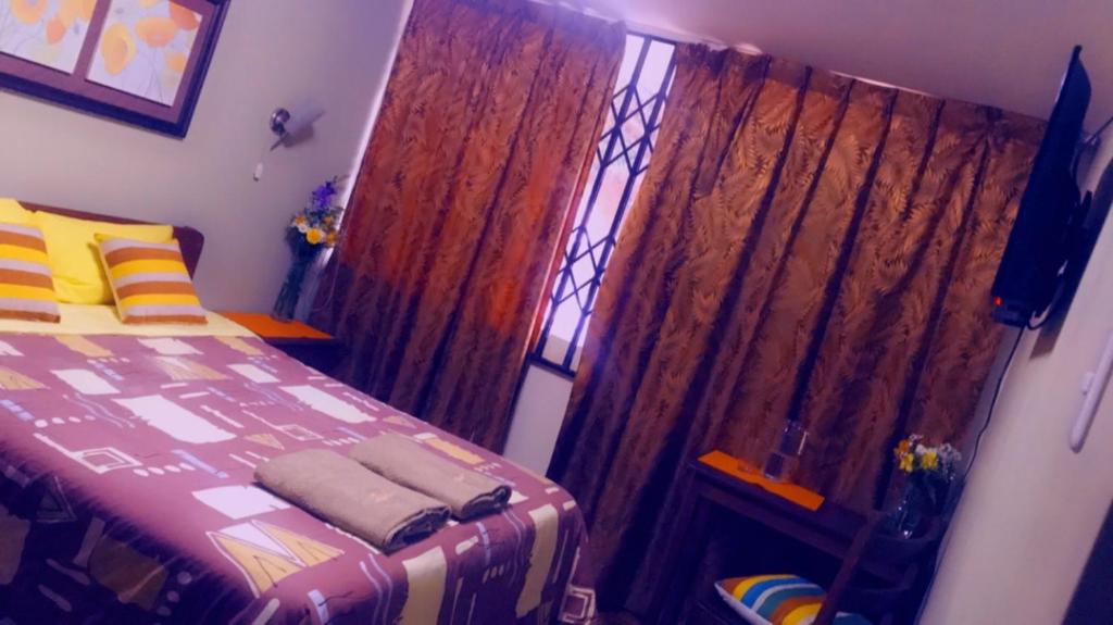 Schlafzimmer mit einem Bett und einem Fenster in der Unterkunft HOTEL VISTA HERMOSA in Trujillo