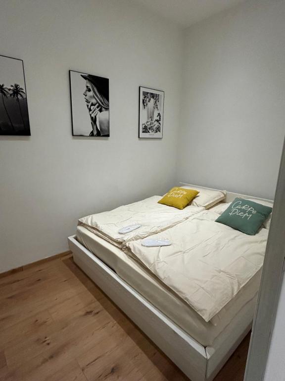 Una cama blanca en una habitación con cuadros en la pared. en Vienna Prater Apartment, en Viena