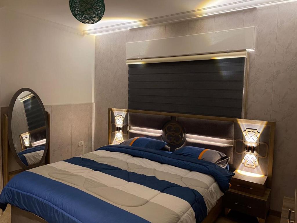 a bedroom with a large bed with a mirror at شركة مسايا لشقق المفروشة in Irbid