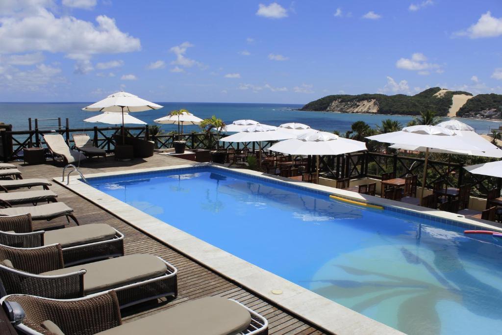 a large swimming pool with chairs and umbrellas at Sunbrazil Hotel - Antigo Hotel Terra Brasilis in Natal