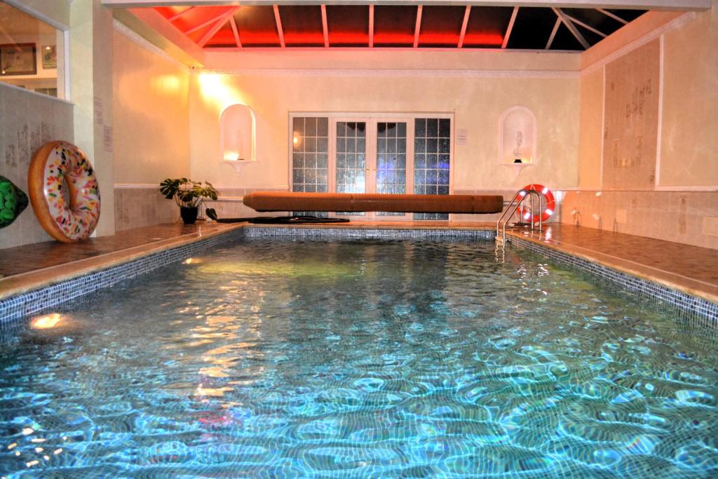 a large swimming pool in a building with a large pool at Family Retreat or Romantic Break 