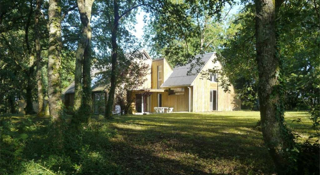 a house in the middle of a yard with trees at Gîte le tuc d'esparre in Orist
