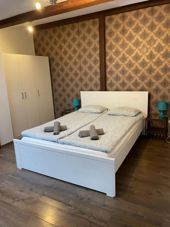 - une chambre avec un lit blanc et des serviettes dans l'établissement Apartament Szafir 4b, à Rzeszów
