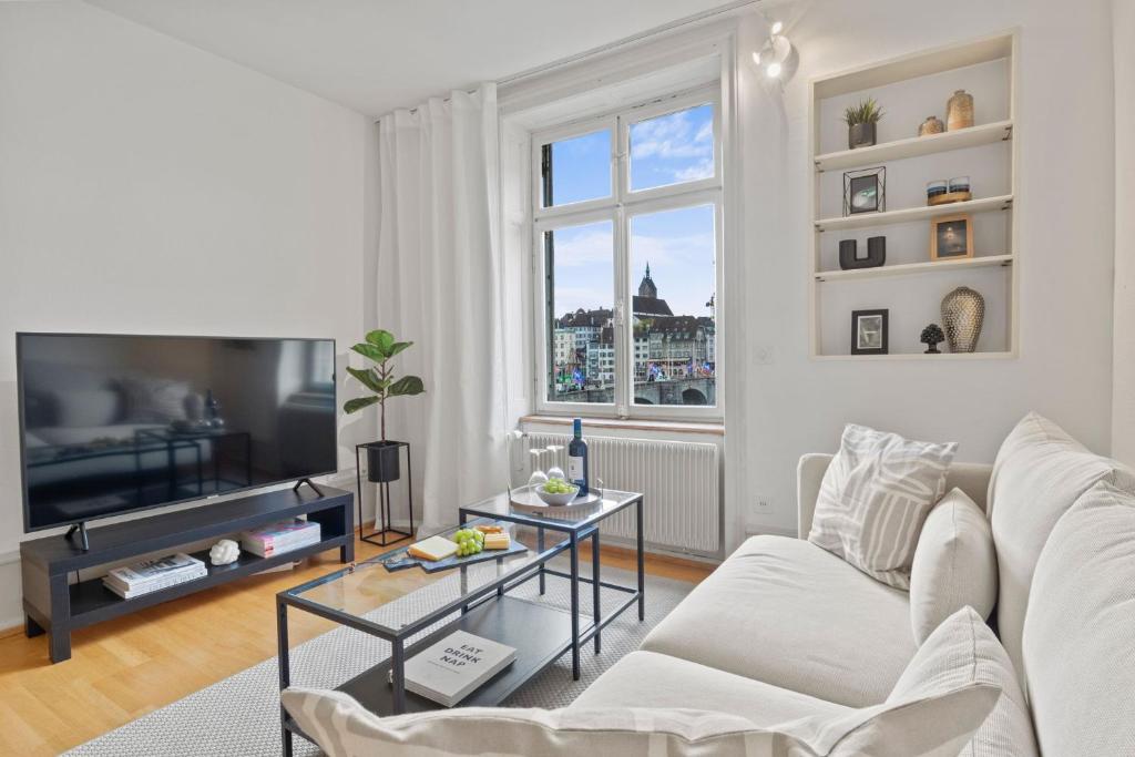 a living room with a white couch and a window at NEU - Citywohnung mit Rheinblick in Basel
