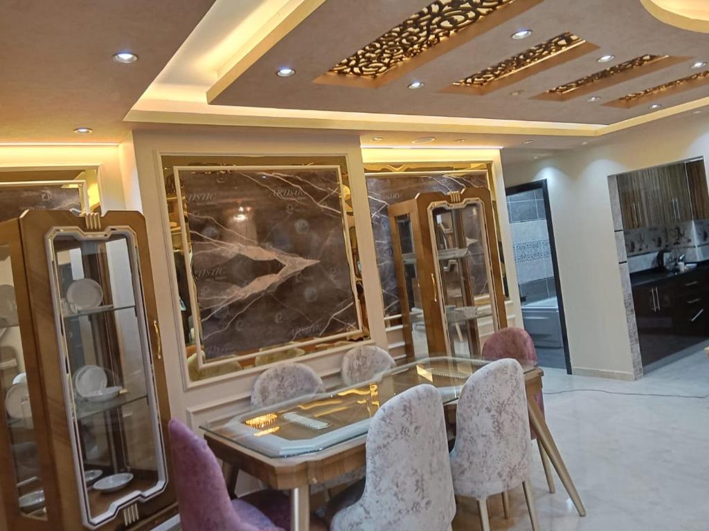 a dressing room with a glass table and chairs at شقة جديدة سوبر لوكس جامعة الدول المهندسين Egyptian Nile Cairo royal furnished apartment in muhandessin in Cairo