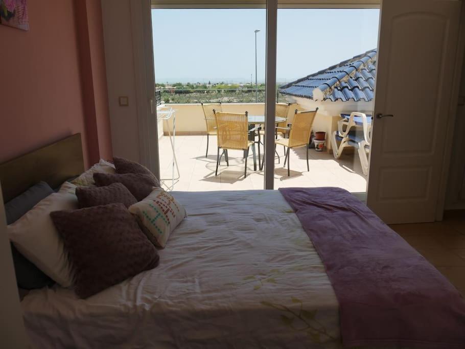 Excelente Duplex en Altaona golf resort-piscinas في مورسية: غرفة نوم بسرير مع اطلالة على فناء