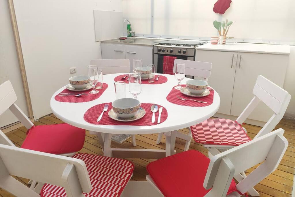 a white table with red napkins and chairs in a kitchen at Departamento en Centro histórico de Cusco (PASEO LOS HEROES) in Cusco