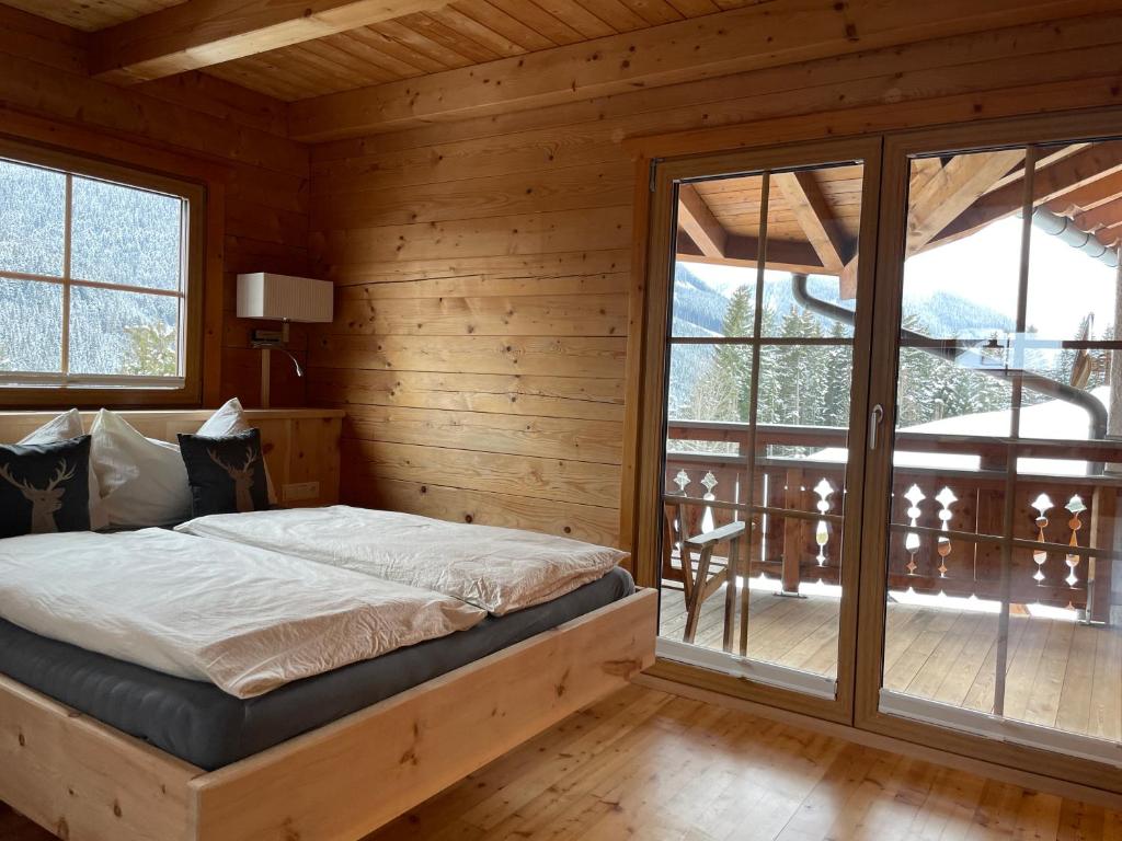 a bedroom with a bed and a balcony at Chalet Kleinbergsonne in Filzmoos