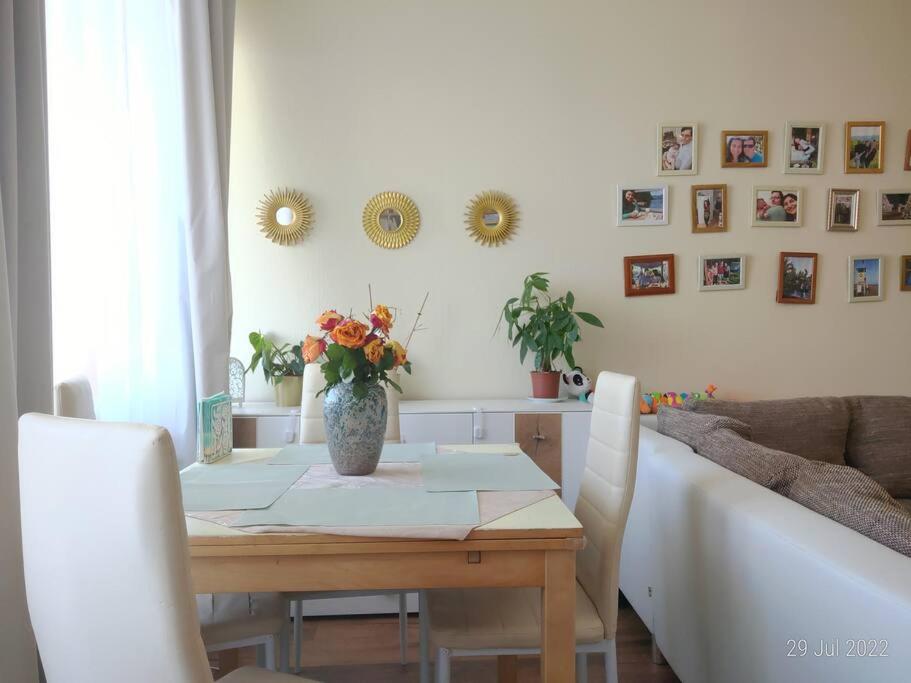 - une table à manger avec un vase de fleurs dans l'établissement Lovely 3-room condo in Berlin, lakes & city center, à Berlin