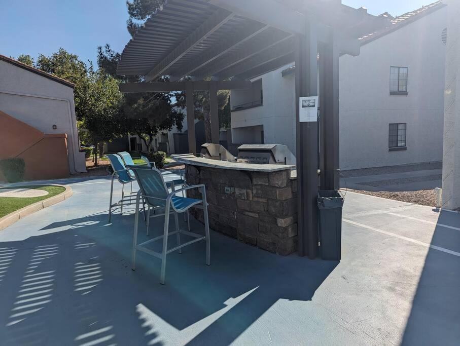 a patio with a bar with chairs and a grill at 2 Bed 2 Bath with pool and spa in Phoenix