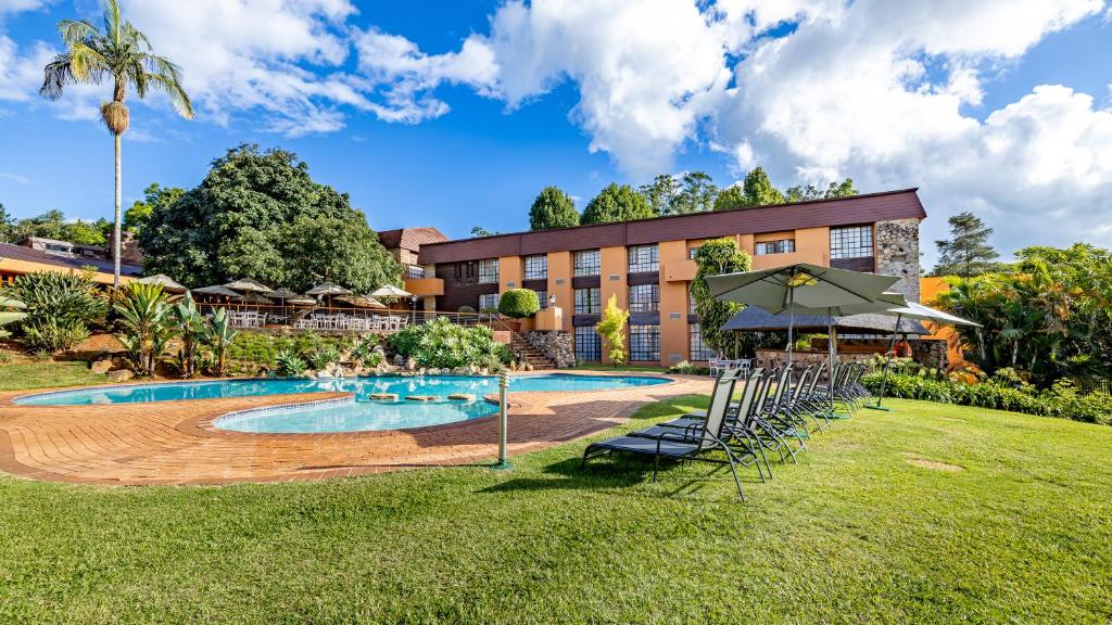 a resort with a pool and a building at African Sky Hotels - Pine Lake Inn in White River