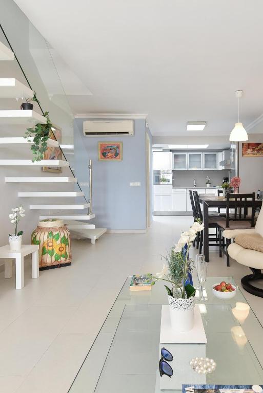 Biały salon ze stołem i schodami w obiekcie Beachfront Apartment Las Burras MRA 02 w mieście San Agustin