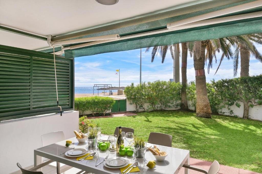 stół z jedzeniem i widokiem na ocean w obiekcie Beachfront Apartment Las Burras MRA 02 w mieście San Agustin