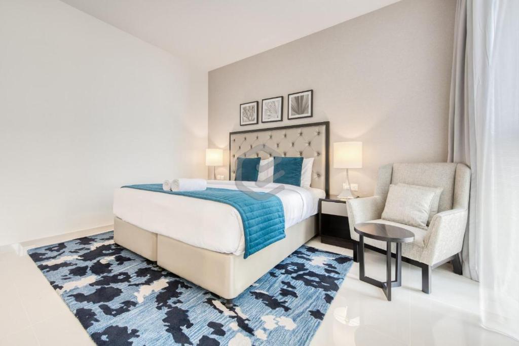 - une chambre avec un grand lit et une chaise dans l'établissement One Bed Apartment in Dubai - Dubai South - Damac Celestia, à Dubaï