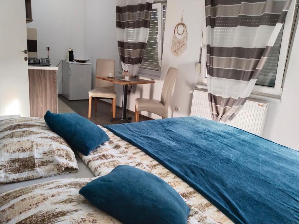 un letto con cuscini blu sopra di Apartman Harmony 2 a Banja Koviljača