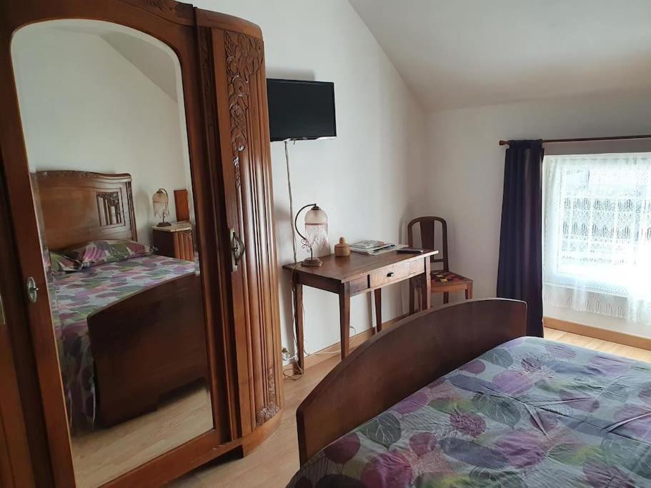 1 dormitorio con cama, espejo y mesa en Logement 'la Hulotte'-10 min d'Auxerre-2h de Paris, 