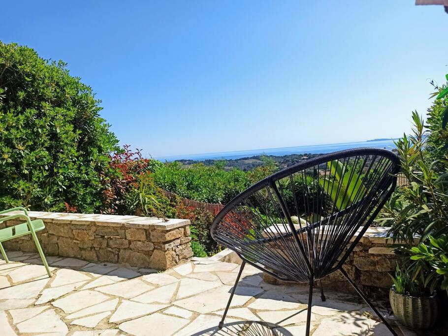 une chaise noire assise sur un patio en pierre dans l'établissement Mas Flora, à La Croix-Valmer