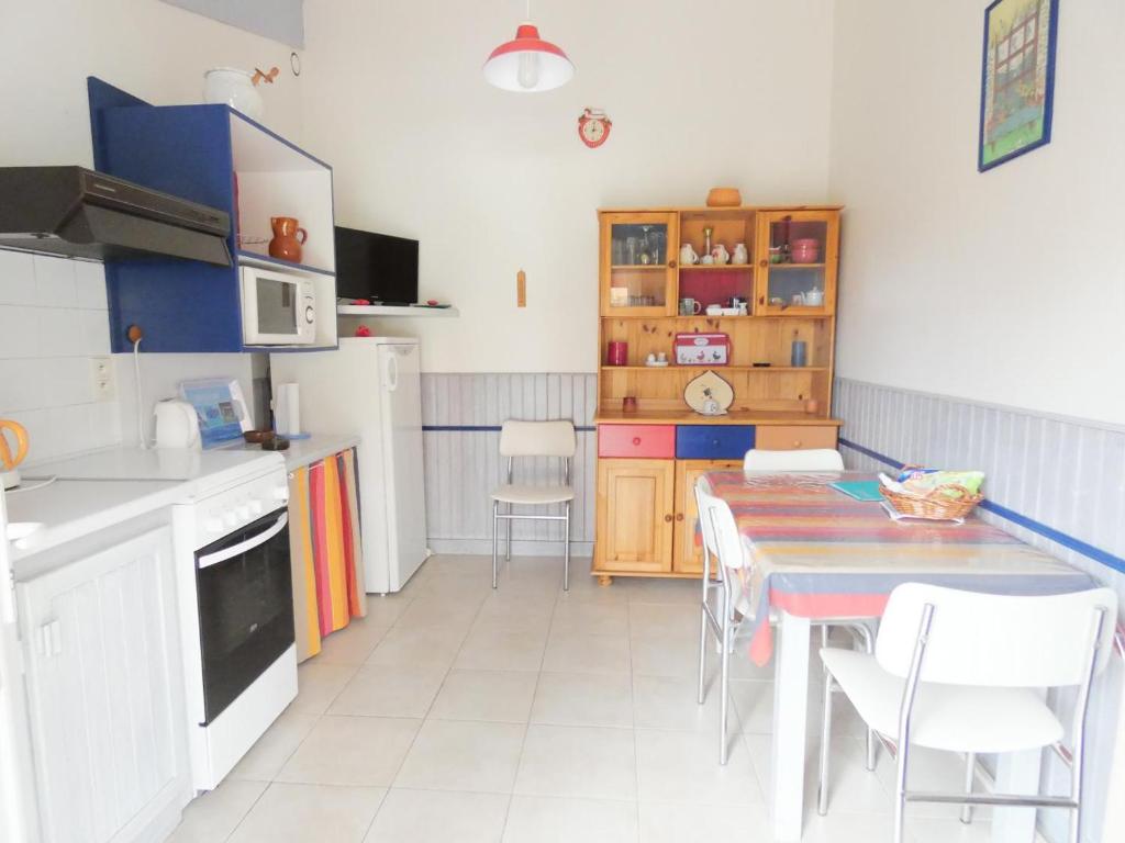 una cocina con mesa y algunas sillas. en L'enclos, en Saint-Geours-de-Maremne